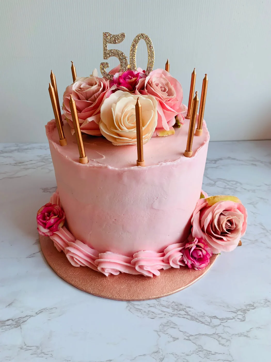 A bespoke pink birthday cake with gold 50 topper